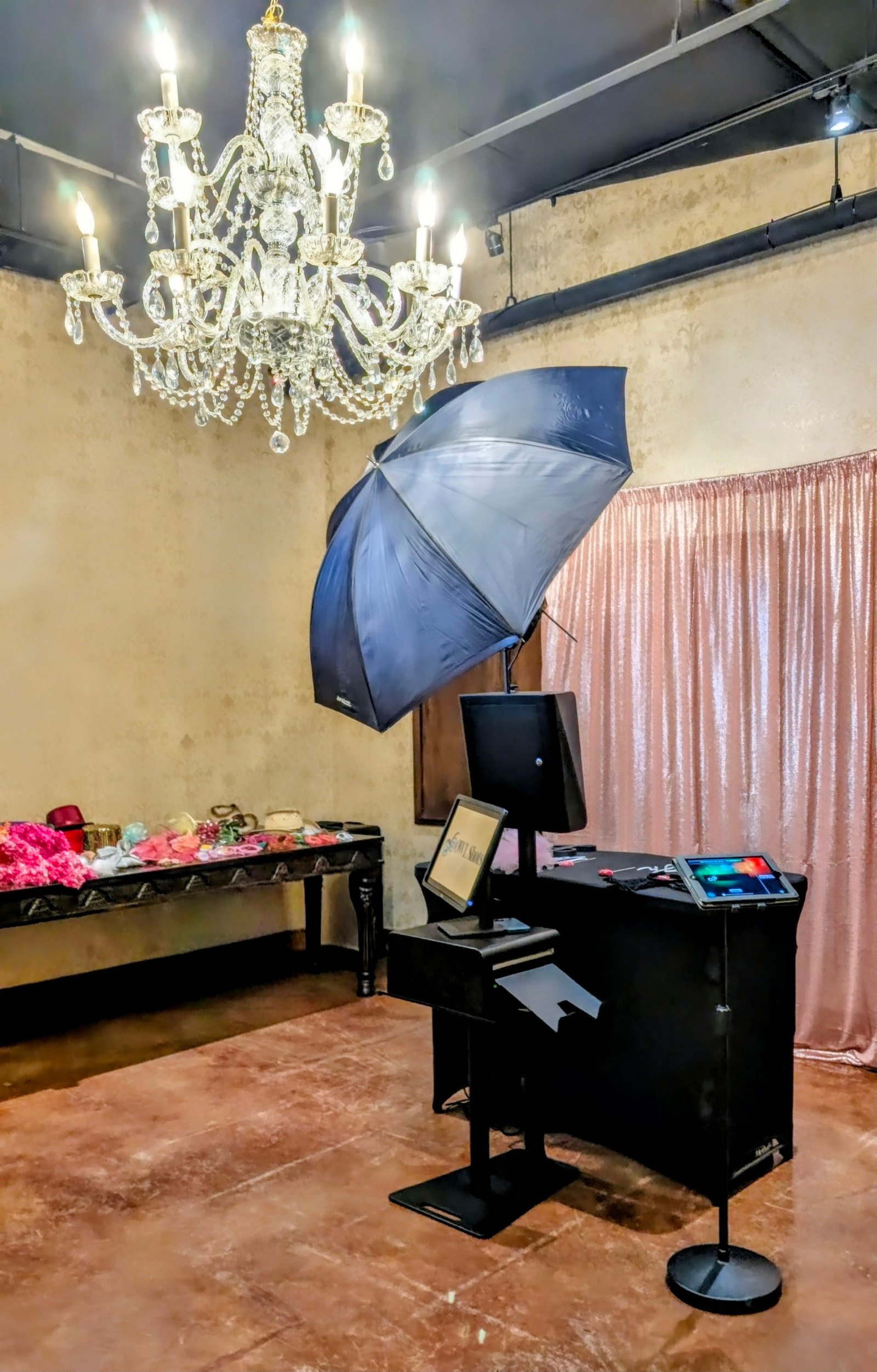 OWLShots photo booth setup at an elegant Houston venue, with a props table and chandelier backdrop